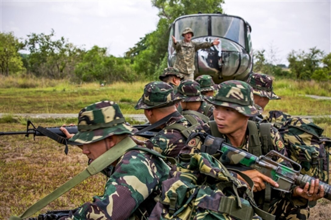 U.S. Army 1st Lt. Brian Johnson, back, discusses helicopter insert and extract procedures with Philippine soldiers as they prepare for Balikatan 2014 on Fort Magsaysay, Philippines, April 29, 2014. This is the 30th year of the exercise, which provides U.S.-Philippine military training and humanitarian assistance. 