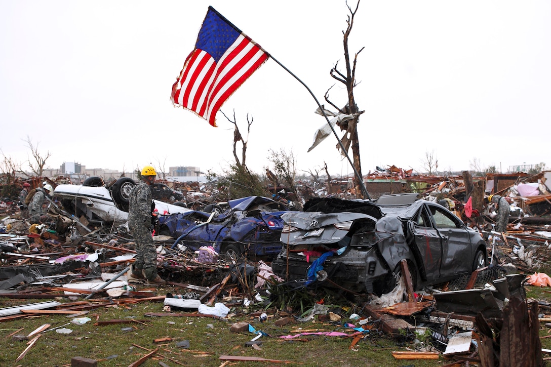 A U.S. flag flies above debris in Moore, Okla., May 21, 2013. Members of the Oklahoma National Guard are working to help the city, which suffered severe damage during a tornado that struck there, May 20. The guardsmen are members of the 63rd Civil Support Team.  
