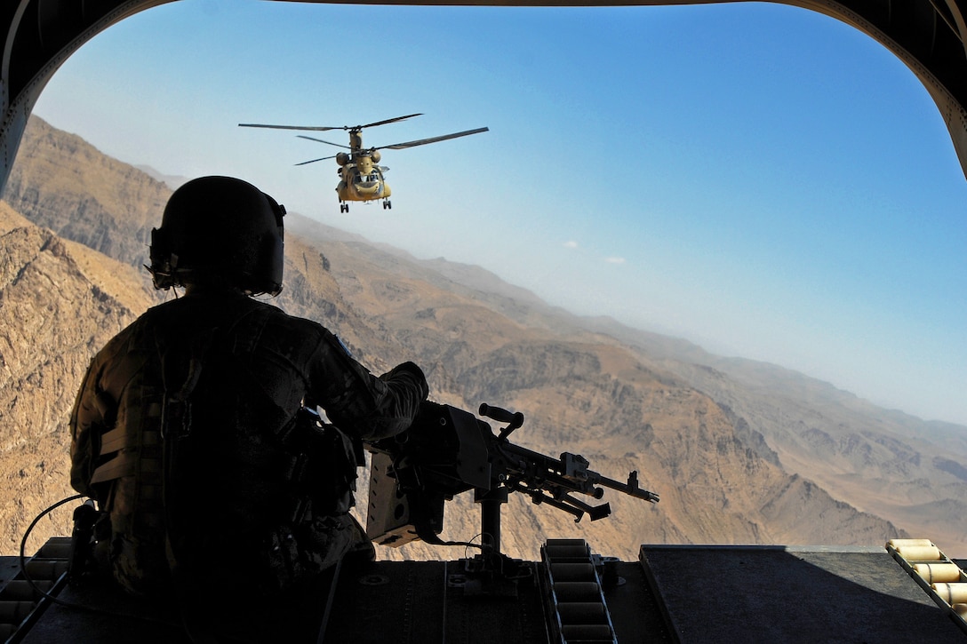 U.S. Army Sgt. Zach Smola, rear door gunner on a CH-47 Chinook helicopter, keeps watch on the mountains in the Chorah district of Uruzgan province, Afghanistan, May 12, 2013. Smola is assigned to Company B, 2nd Battalion, 104th Aviation Regiment, Connecticut and Pennsylvania Army National Guard.  
