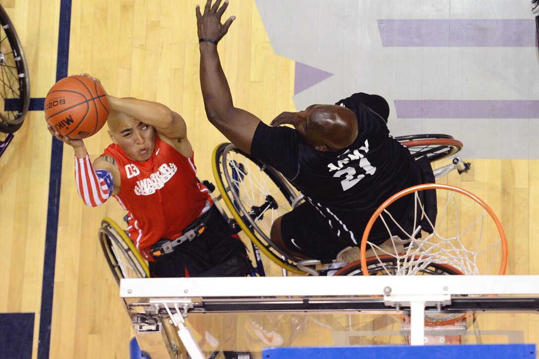 Marine Corps Cpl. Josue Barron, left, puts up a shot as Army veteran Perry Price attempts a block during the gold medal wheelchair basketball match of the 2013 Warrior Games in Colorado Springs, Colo., May 15, 2013. Army won the gold, 34-32.  
