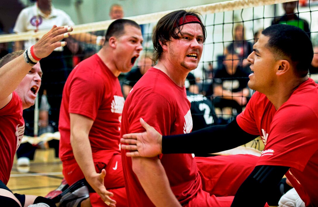 Marine Corps sitting volleyball teammates celebrate a hard-earned point against the Army during the sitting volleyball tournament during the 2013 Warrior Games in Colorado Springs, Colo., May 13, 2013.  
