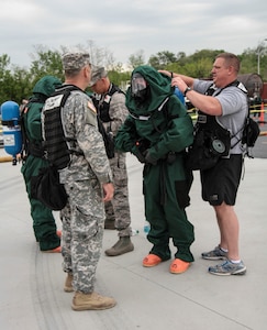 First responders from West Virginia National Guard 35th Civil Support Team help each other gear up for a practice exercise held at Harrisburg Area Community College on May 12, 2014, as part of Vigilant Guard 2014. Members of civilian and military first responder teams came together for this event which is held in different states four times a year.
