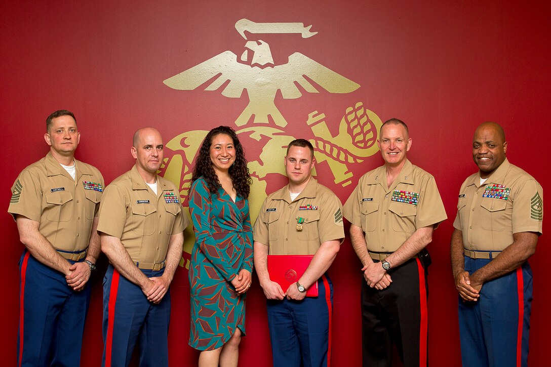 Sgt. Jason Howton (fourth from left), a recruiter assigned to Marine Corps Permanent Contact Station Port Angeles, Wash., poses with his wife and command members of Marine Corps Recruiting Command and Marine Corps Recruiting Station Seattle following an awards ceremony at MCRS Seattle, April 15, 2014. During the ceremony, Howton received a Navy and Marine Corps Achievement Medal for his exceptional contribution to MCRS Seattle’s recruiting mission. Howton, 27, is from Milton, Fla.