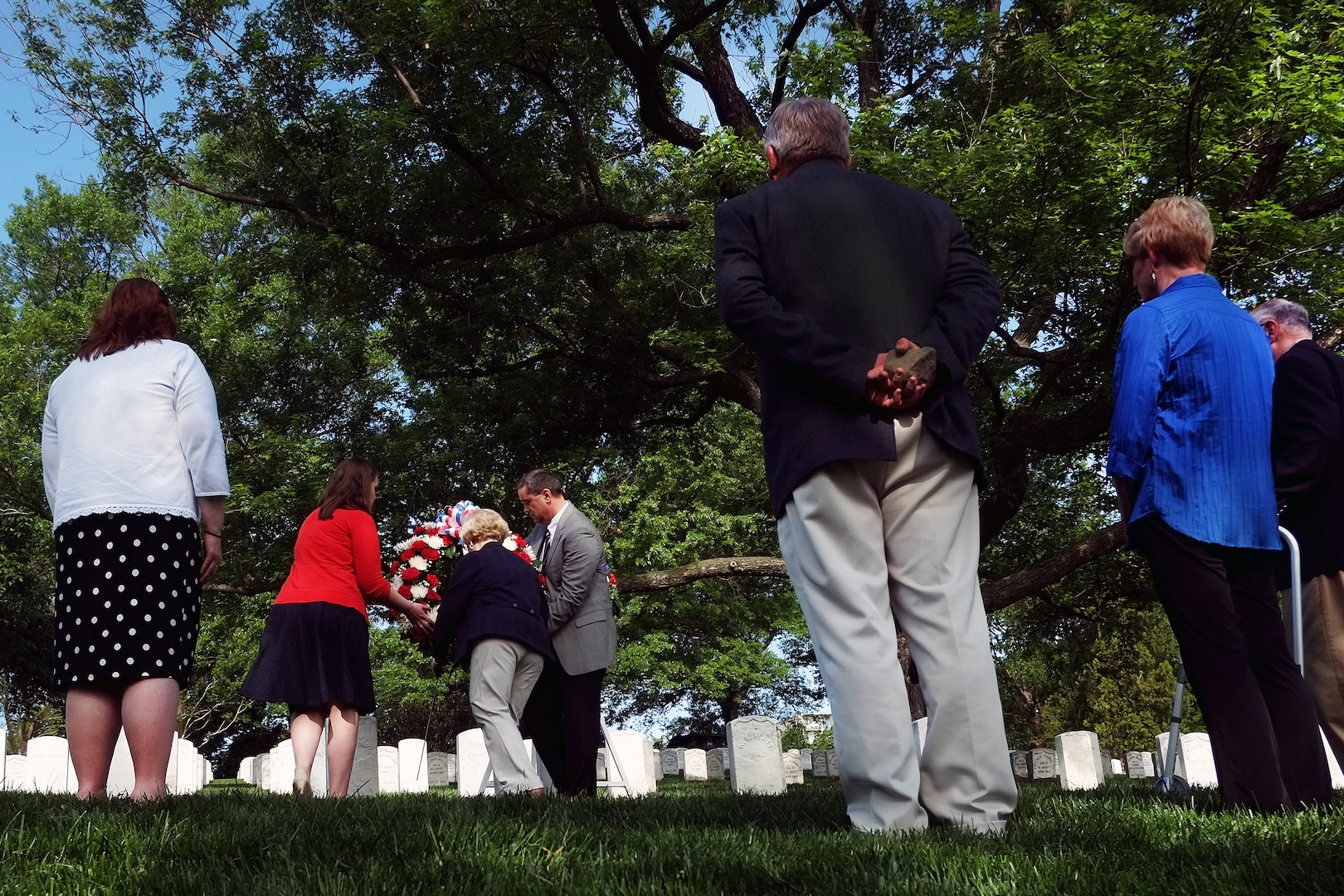 As other family members look on, Barbara Christman Page, center, Lauren Christman, left in red, and Jim Christman lay a wreath at the grave of Army Pvt. William Christman, of the 67th Pennsylvania Infantry Regiment and the first Soldier interred at Arlington National Cemetery, during a ceremony at the cemetery marking the 150th anniversary of Pvt. Christman's burial and the start of Arlington as a burial ground.