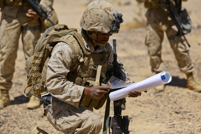 Corporal Bereket Berhane, a warehouse clerk with Headquarters Battalion, 1st Marine Division, maps out a security patrol route during Exercise Desert Scimitar at Marine Corps Air Ground Combat Center Twentynine Palms, Calif., May 12, 2014. It is not uncommon for Marines like Berhane, a native of Dallas, to be called upon to maintain security during field training. 1st Marine Division acts as the headquarters element of I Marine Expeditionary Force during the exercise. (U.S. Marine Corps photograph by Sgt. Timothy Lenzo/RELEASED)