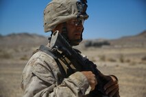 Sergeant Joseph Hoffmann, a Marine musician with Headquarters Battalion, 1st Marine Division, prepares for a security patrol during Exercise Desert Scimitar at Marine Corps Air Ground Combat Center Twentynine Palms, Calif., May 12, 2014. The security platoon is comprised of Marines of varying jobs including band members, motor transport operators and data wire technicians. They come together to provide security for 1st Marine Division during the exercise, maintaining an entry control point and conducting patrols around the camp. (U.S. Marine Corps photograph by Sgt. Timothy Lenzo/RELEASED)