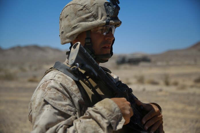 Sergeant Joseph Hoffmann, a Marine musician with Headquarters Battalion, 1st Marine Division, prepares for a security patrol during Exercise Desert Scimitar at Marine Corps Air Ground Combat Center Twentynine Palms, Calif., May 12, 2014. The security platoon is comprised of Marines of varying jobs including band members, motor transport operators and data wire technicians. They come together to provide security for 1st Marine Division during the exercise, maintaining an entry control point and conducting patrols around the camp. (U.S. Marine Corps photograph by Sgt. Timothy Lenzo/RELEASED)