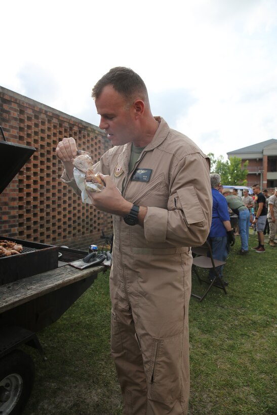 Lt. Col. Alan Solter, commanding officer of Marine Wing Headquarters Squadron 2,  enjoys a piece of chicken behind the barracks here during an even hosted by the New Bern Military Alliance May 7. The 2014 Spring Chicken Picking is one of the many events sponsored by the organization aimed at fostering camaraderie between service members and their families.