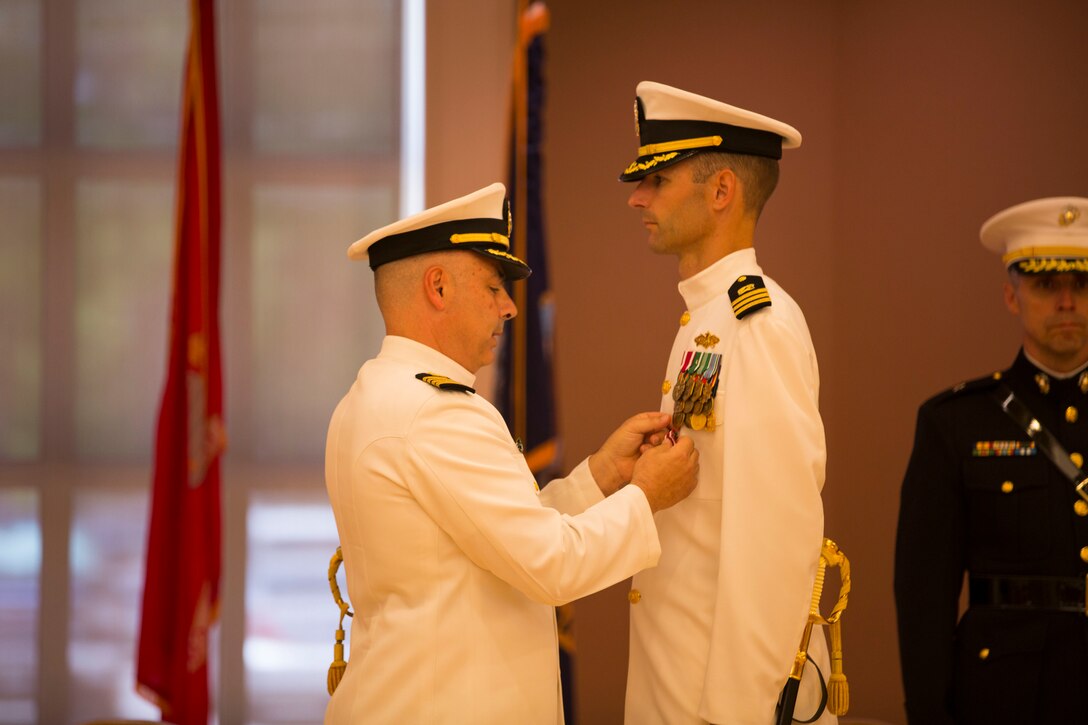 Cmdr. Scott Cloyd, the outgoing officer in charge of construction, receives an award during the disestablishment ceremony of Marine Corps Installations East Officer in Charge of Construction office at the Marston Pavilion aboard Marine Corps Base Camp Lejeune, May 6. The OICC was a unique office created to manage a large influx in construction during the last six years. Cloyd has led the OICC for the last two years.  