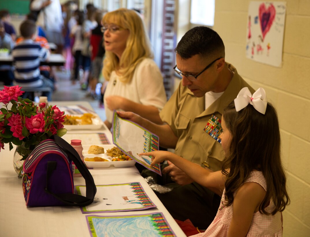 Brig. Gen. Robert Castellvi, the commanding general of Marine Corps Installations East – Marine Corps Base Camp Lejeune speaks with Evoli, a military child, about art at Parkwood Elementary School in Jacksonville, N.C, May 7. Evoli won a lunch with Castellvi at a raffle held during the All-American Family Night, an event hosted by the Camp Lejeune School Liaison in April.