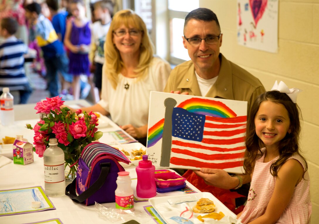 Brig. Gen. Robert Castellvi, the commanding general of Marine Corps Installations East – Marine Corps Base Camp Lejeune holds a painting given to him by Evoli, a military child, at Parkwood Elementary School in Jacksonville, N.C, May 7. Evoli won a lunch with Castellvi at a raffle held during the All-American Family Night, an event hosted by the Camp Lejeune School Liaison in April.