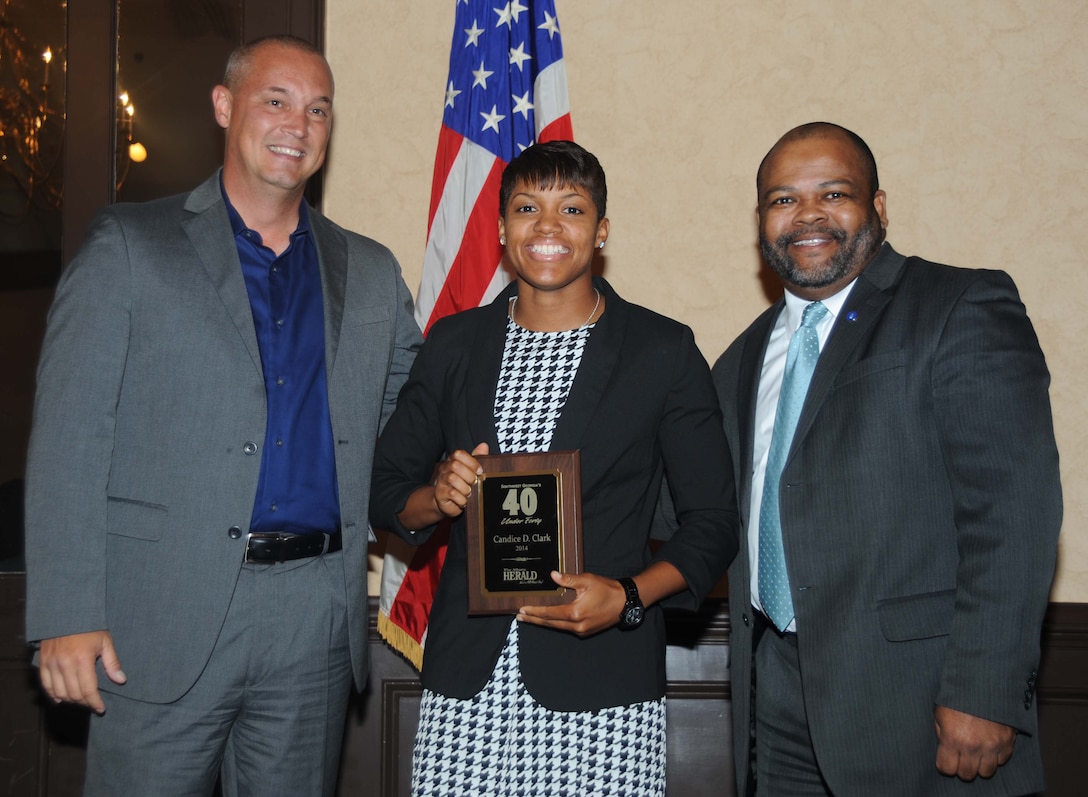 Cpl. Candice Clark, operations noncommissioned officer, Support Operations Branch, Marine Corps Systems Command (center), receives the 2014 40 under 40 Award following the May 1 ceremony held at Stonebridge Golf and Country Club in Albany, Ga. Posing with Clark is Chris Hardy, president and CEO of the Albany Area Chamber of Commerce (left), and Ken Boler, general sales manager, The Albany Herald. 