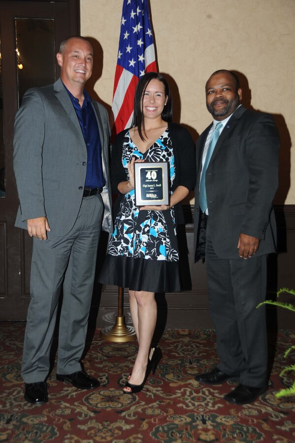 Staff Sgt. Juana Snell, equal opportunity advisor, Marine Corps Logistics Command (center), receives the 2014 40 under 40 Award during an annual ceremony held at Stonebridge Golf and Country Club in Albany, Ga., May 1. Snell received the award from Chris Hardy, president and CEO of the Albany Area Chamber of Commerce (left), and Ken Boler, general sales manager, The Albany Herald.