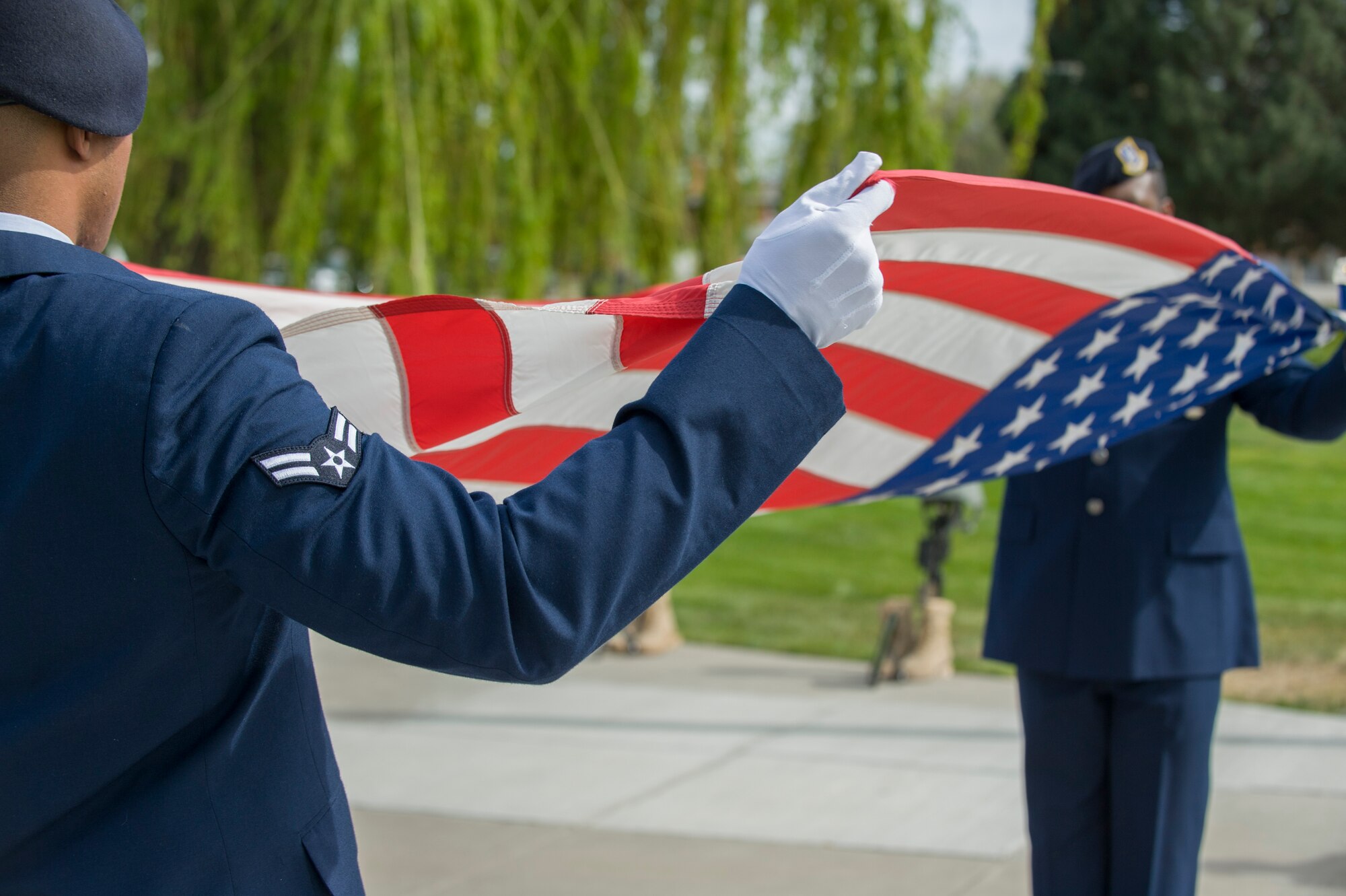 Airman 1st Class Stanley McDonald and Senior Airman Joshua McNair, defenders from the 366th Security Forces Squadron, fold the American Flag during Peace Officers Memorial Day retreat ceremony at Mountain Home Air Force Base, Idaho, May 15, 2014. President John F. Kennedy designated May 15th as Peace Officers Memorial Day and the week in which it falls as Police Week. (U.S. Air Force photo by Staff Sgt. Roy Lynch III/RELEASED)