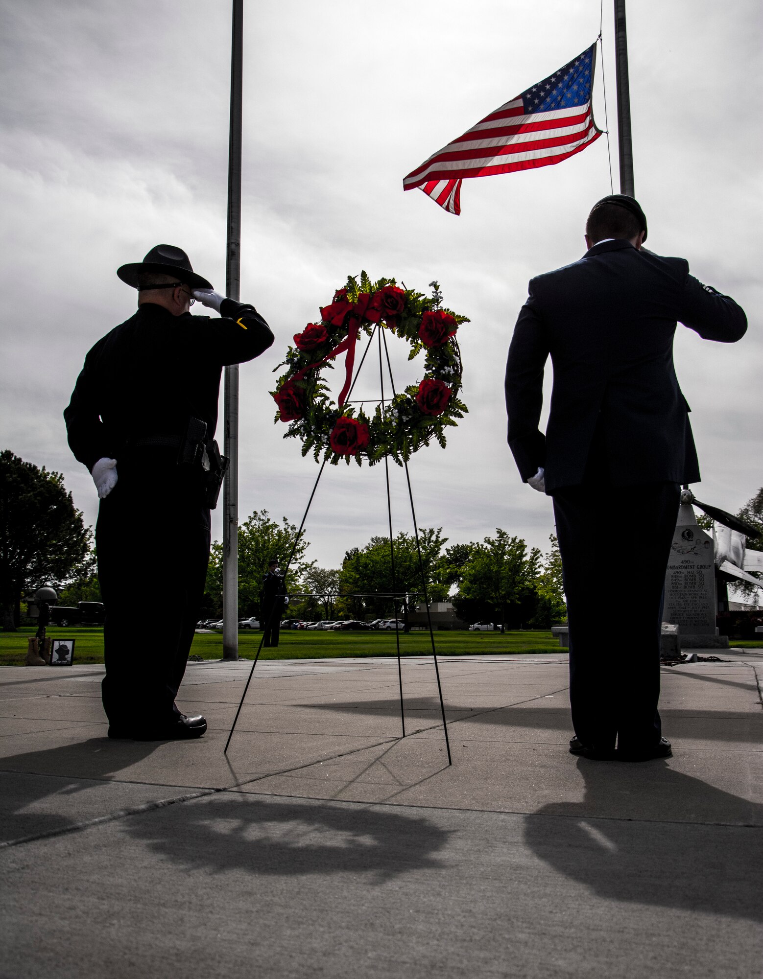 Corporal Stan Winings, Mountain Home Police Department community affairs, and Senior Airman Christopher Hotine, 366th Security Forces Squadron defender, salutes the American Flag and a wreath during Peace Officers Memorial Day retreat ceremony at Mountain Home Air Force Base, Idaho, May 15, 2014. Security Forces held different events and activities to commemorate Peace Officers Memorial Day and National Police Week from May 13 to 17. (U.S. Air Force photo by Staff Sgt. Roy Lynch III/RELEASED)