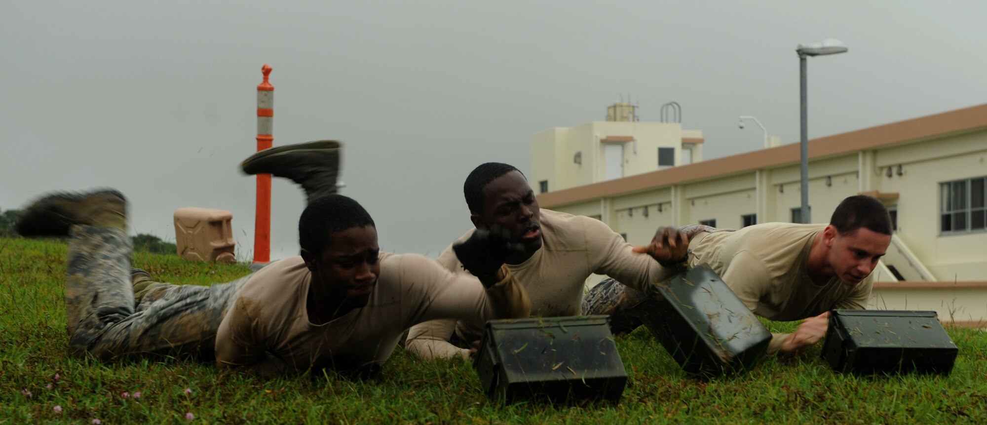 Participants push ammo cans downhill during the 2014 Defenders Challenge in support of Police Week on Kadena Air Base, Japan, May 13, 2014. This year's Defenders Challenge included members of various squadrons taking part in live ammunition firing and components of the United States Marine Corps physical fitness test, all of which test the physical and mental capability of the members in the law enforcement. (U.S. Air Force photo by Airman 1st Class Keith James)