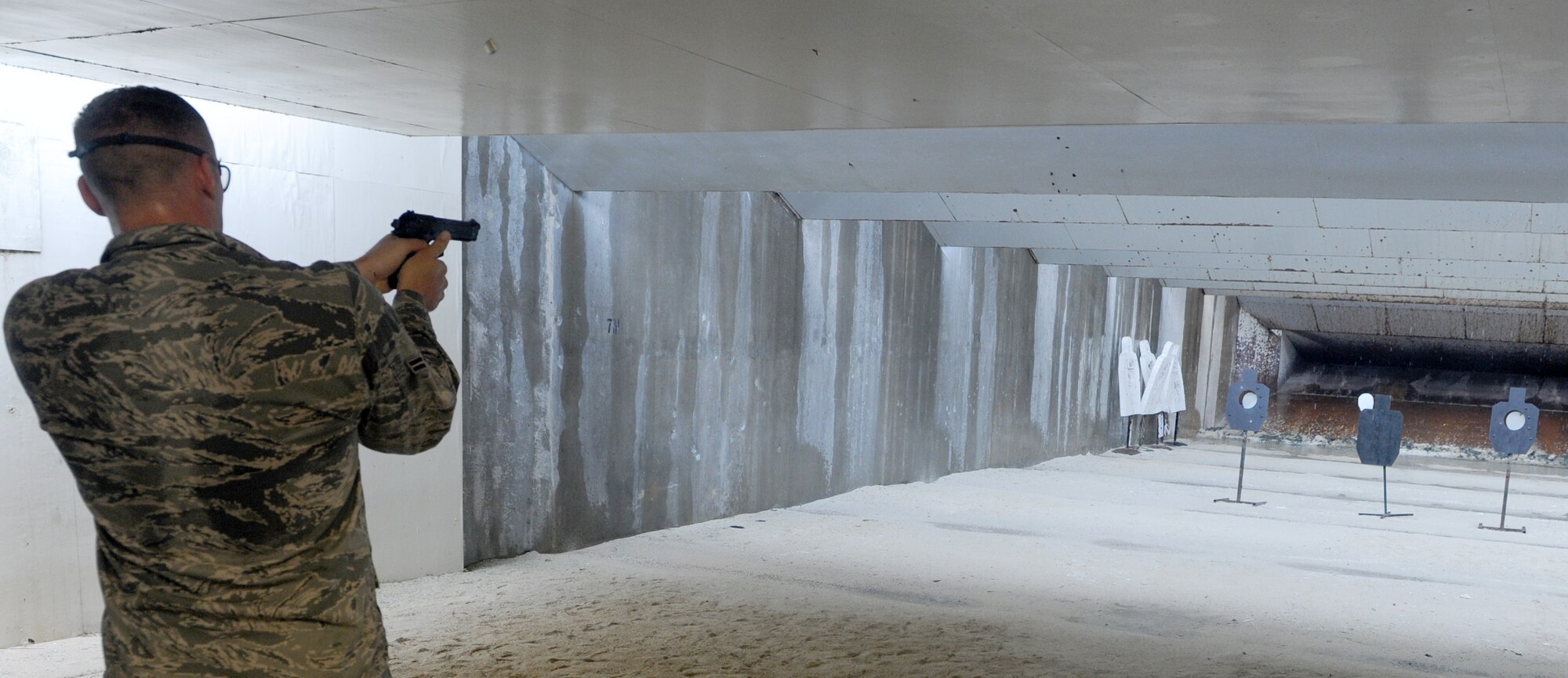 U.S. Air Force Airman 1st Class Richard Anderson, 18th Security Forces Squadron venture flight member, fires an M-9 pistol at targets on the firing range of Kadena Air Base, Japan, during the Defenders Challenge, May 13, 2014. This year's Defenders Challenge included members of various squadrons taking part in live ammunition firing and components of the United States Marine Corps physical fitness test, all of which test the physical and mental capability of the members in the law enforcement. (U.S. Air Force photo by Airman 1st Class Keith James)