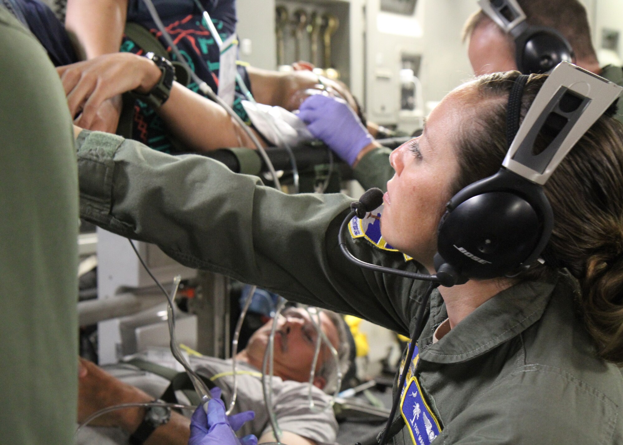 Tech Sgt. Maria Wesloh,315th Aeromedical Evacuation Squadron, assists in providing emergency in-flight care to a simulated litter patient during a multi-agency patient evacuation exercise held at Joint Base Charleston and in Greenville, S.C., May 14, 2014. The exercise was organized through the National Disaster Medical System, which coordinates several federal, state and local emergency response agencies in times of crisis and mass casualty. (U.S. Air Force photo by Senior Airman Meredith A. H. Thomas)
