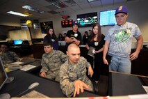 Airman 1st Class Matthew Paski, 2nd Space Operations Squadron, briefs Ellicott High School students during the Job Shadow Day May 9, 2014, at Schriever Air Force Base, Colo. The students toured the unit’s operations floor, learned about the mission and how Airmen here interact with satellites in space. (U.S. Air Force photo/Dennis Rogers)