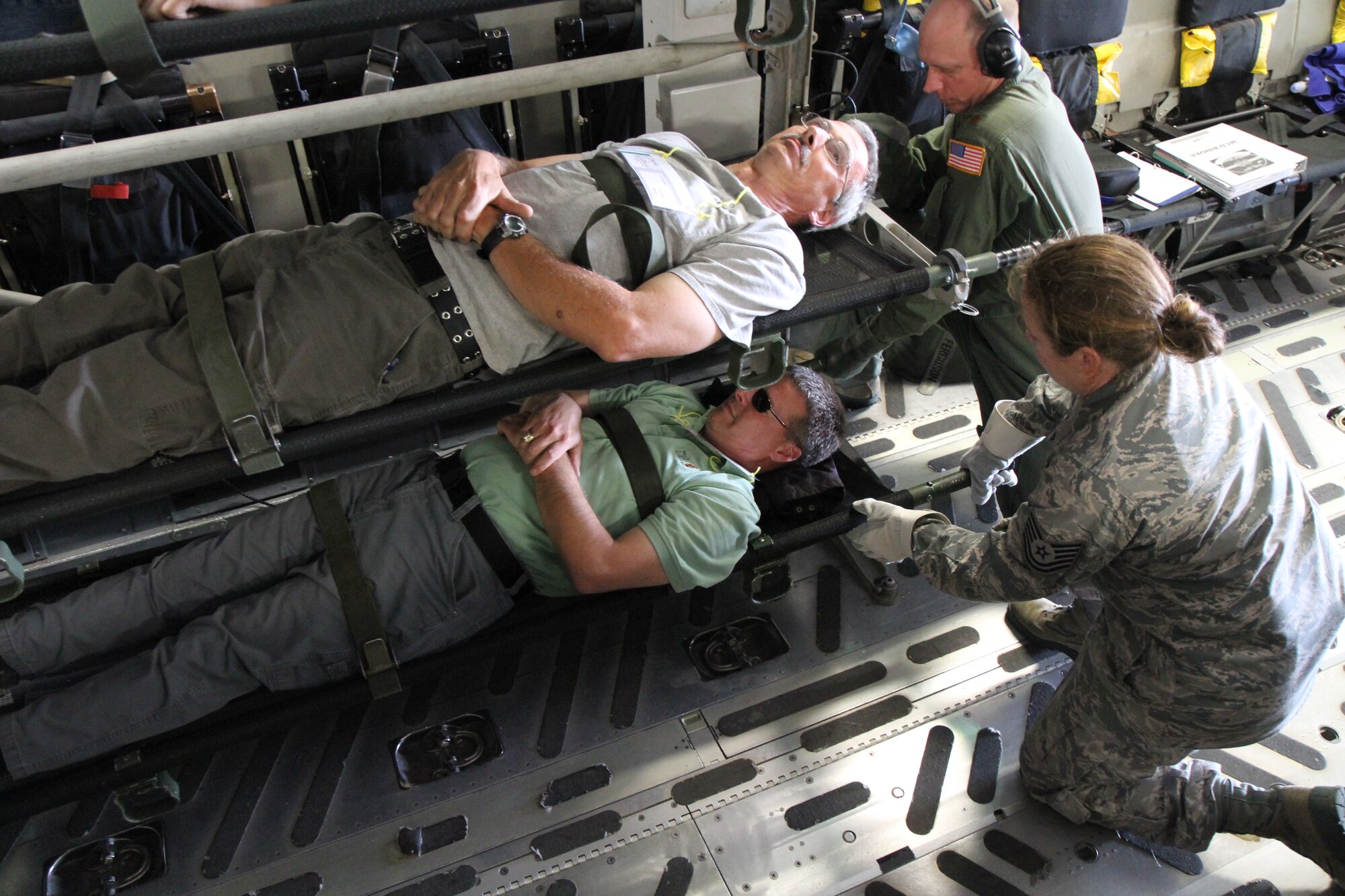 Maj. Ryan Murray,315th Aeromedical Evacuation Squadron flight nurse, and Tech. Sgt. Barbara Clutter, 315th Aerospace Medicine Squadron optometry technician, transfer a simulated litter patient onto a stanchion in preparation for flight during a multi-agency patient evacuation exercise held at Joint Base Charleston and in Greenville, S.C., May 14, 2014. The exercise was organized through the National Disaster Medical System, which coordinates several federal, state and local emergency response agencies in times of crisis and mass casualty. (U.S. Air Force photo by Senior Airman Meredith A. H. Thomas)