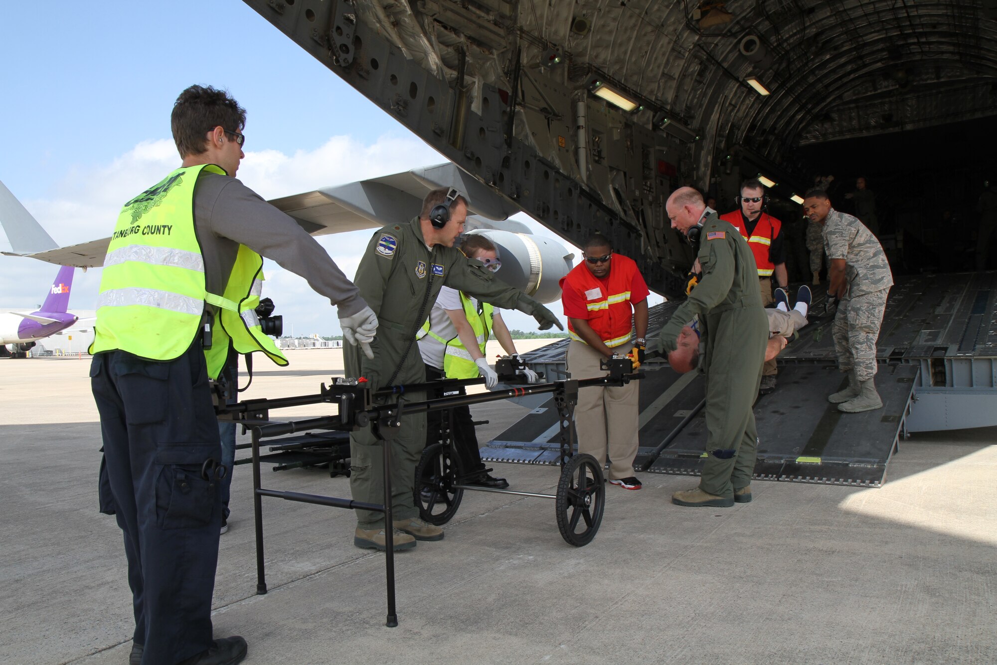 Maj. David Ferguson, medical crew director with the 315th Airlift Wing based out of Joint Base Charleston, S.C., directs the offloading of a simulated litter patient during a multi-agency patient evacuation exercise held at the base and in Greenville, S.C., May 14, 2014. The exercise was organized through the National Disaster Medical System, which coordinates several federal, state and local emergency response agencies in times of national disaster and mass casualty. (U.S. Air Force photo by Senior Airman Meredith A. H. Thomas)
