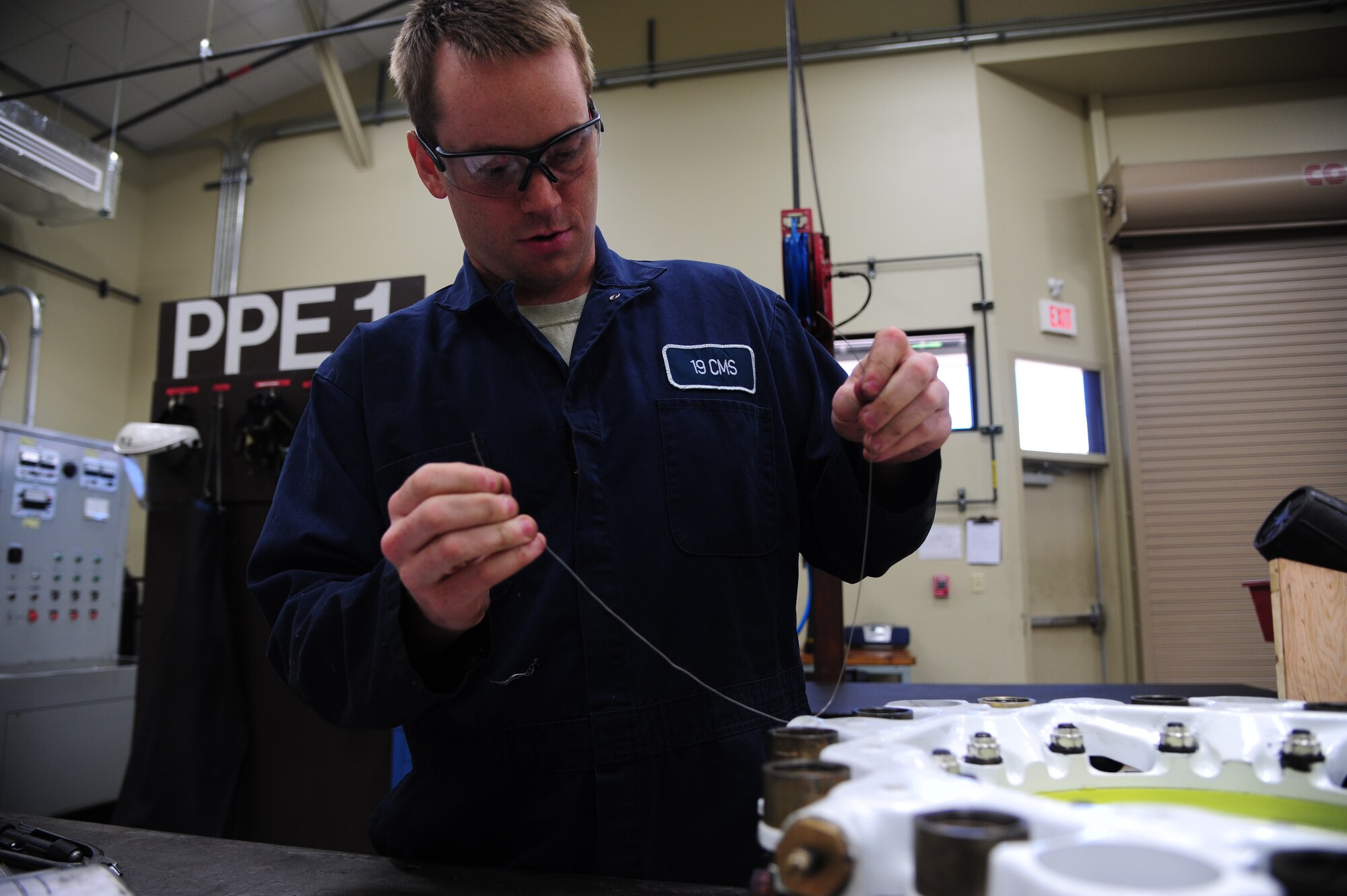 Airman 1st Class Brian Pullen, a 19th Component Maintenance Squadron hydraulics apprentice, attaches safety cable May 1, 2014, at Little Rock Air Force Base, Ark. The safety cables are fitted to the brake after they have been inspected and cleaned to prevent the nuts from moving. (U.S. Air Force photo by Senior Airman Kaylee Clark)
