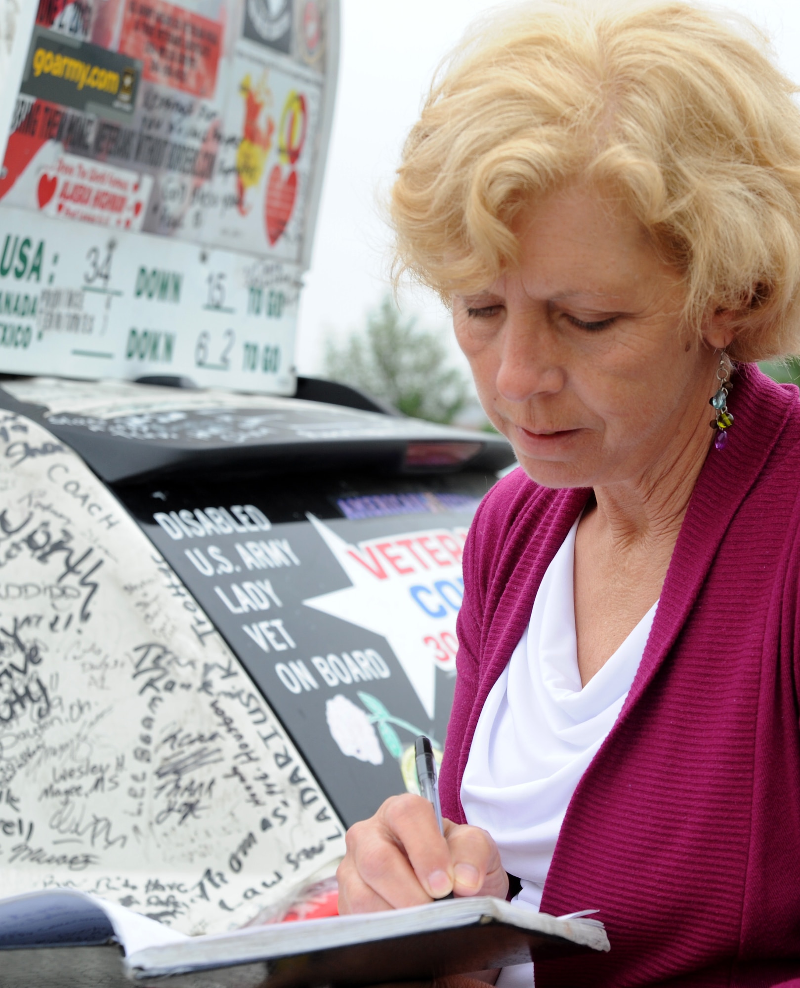 Anita Lamaallem writes a message in Lisa Groves’ signature book at Joint Base Andrews, Md., May 14, 2014. The signature book contains the names of individuals who signed Groves’ car to show their support for service members past and present. Groves has two additional notebooks which have already been filled with signatures. Groves is a former U.S. Army Solider and is now a veteran’s advocate. Lamaallem works in the Air Force District of Washington logistics directorate in support agreements and plans. (U.S. Air Force photo/Master Sgt. Tammie Moore)