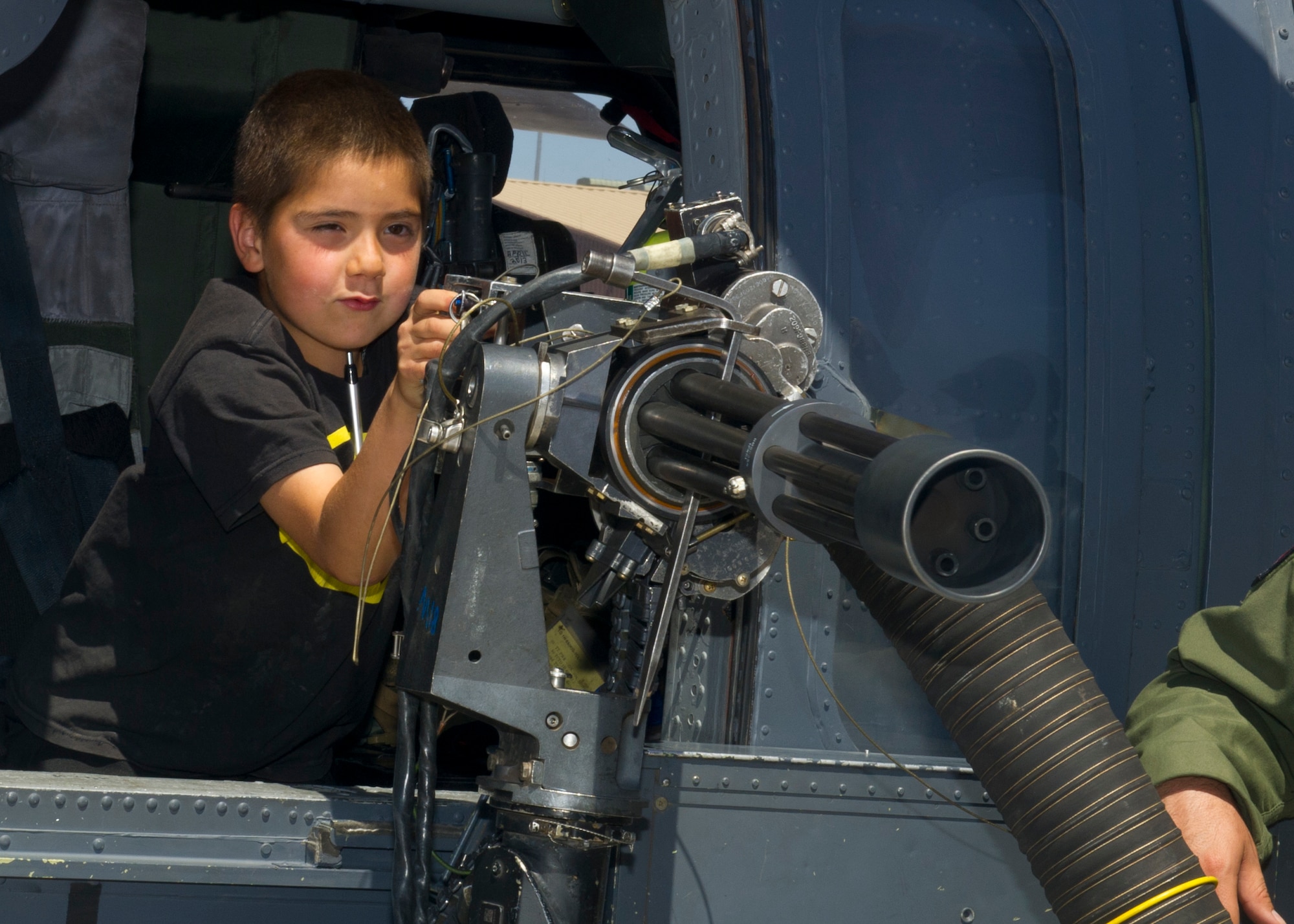 A guest tests out the weaponry on an HH-60 Pave Hawk helicopter during the Open House event at Holloman Air Force Base, N.M., May 10. Team Holloman hosted an Open House showcasing over 50 aircraft and the day-to-day duties of Holloman Airmen. With live flying demonstrations and static displays, thousands of guests attended the event to get a close-up look at the base’s assets and capabilities. Guests were able to view various aircraft, visit numerous vendors, and witness ground demonstrations from squadrons around the base. (U.S. Air Force photo by Airman 1st Class Leah Ferrante/Released) 