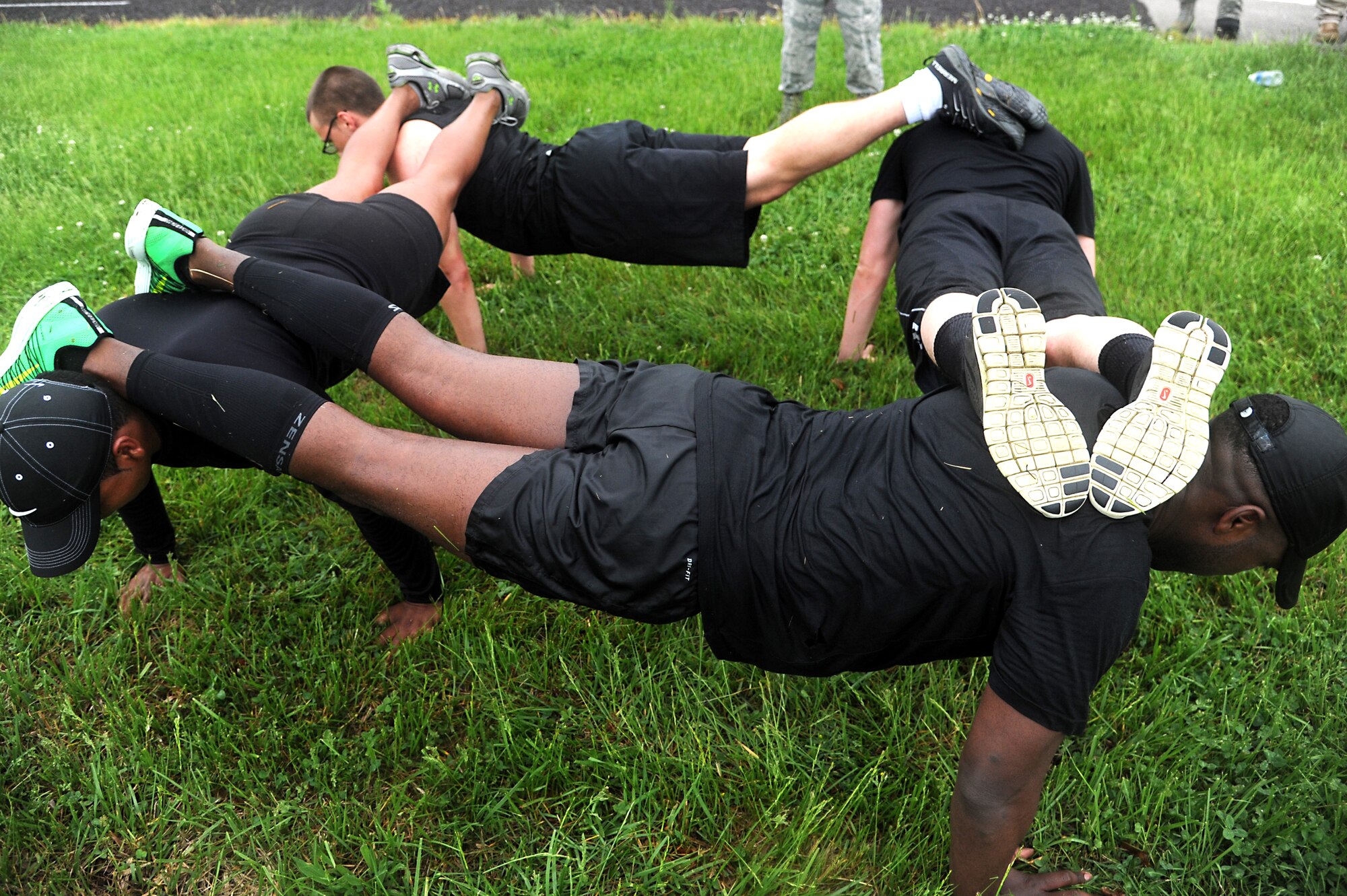 Team 1 members perform fire-team push-ups during the last obstacle during an obstacle for Police Week May 13, 2014, Scott Air Force Base, Ill. A minimum of five push-ups were required to pass the obstacle without any penalty, any team with less than five push-ups had a five minute penalty added to their time but for every push-up over five one minute was taken off the overall finish time. (U.S. Air Force photo/Senior Airman Tristin English)