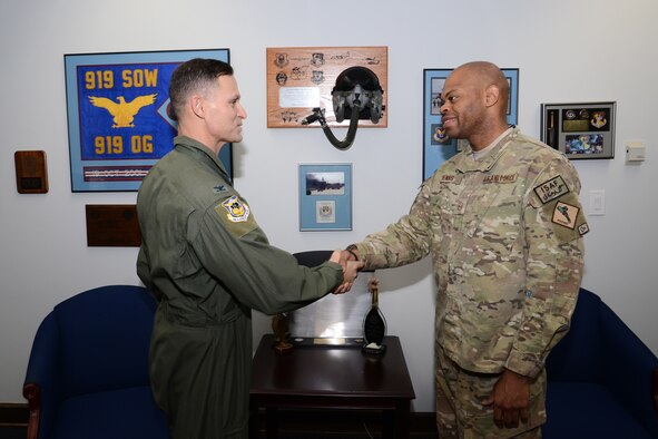 Col. Brett Clark, 94th Airlift Wing commander, congratulates Master Sgt. Travon Dennis, 94th Logistics Readiness Squadron first sergeant, on completing a recent deployment to Camp Bastain, Afghanistan where he served as first sergeant for the 651st Air Expeditionary Group in Jan. (U.S. Air Force photo/Brad Fallin)