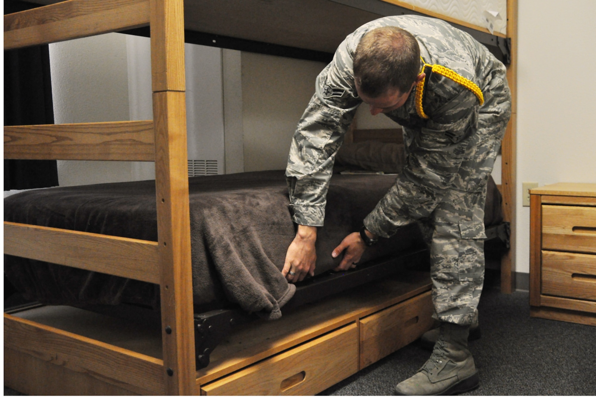 GOODFELLOW AIR FORCE BASE, Texas – Airman 1st Class Bradley Jenkins, 312th Training Squadron student and Airmen leader, makes his bed in his dorm room here April 23. Jenkins plans to take his leadership qualities to Ramstien Air Base, Germany, his next duty station and plans on making the Air Force a career, serving for at least 20 years. (U.S. Air Force photo/ Airman 1st Class Breonna Veal) 