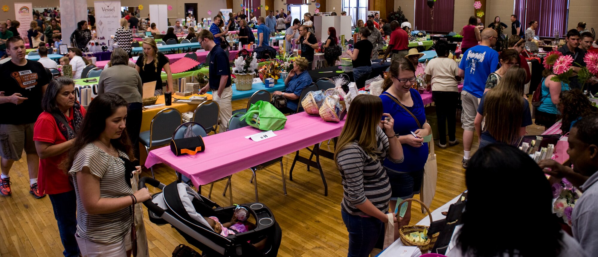 Spouses gather at the Thomas Community Activities Center for the Spouse Appreciation Day Bazaar May 9, 2014, at Little Rock Air Force Base, Ark. Spouses and their families from all branches of service, whether active duty or retired, were welcomed to enjoy the festivities of the events. (U.S. Air Force photo by Airman 1st Class Cliffton Dolezal)
