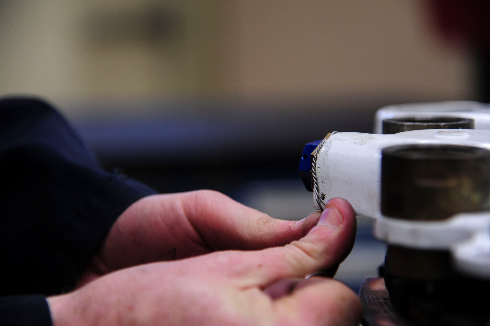 Airman 1st Class Brian Pullen, a 19th Component Maintenance Squadron hydraulics apprentice, attaches safety cable May 1, 2014, at Little Rock Air Force Base, Ark. The safety cables are fitted to the brake after they have been inspected and cleaned to prevent the nuts from moving. (U.S. Air Force photo by Senior Airman Kaylee Clark)