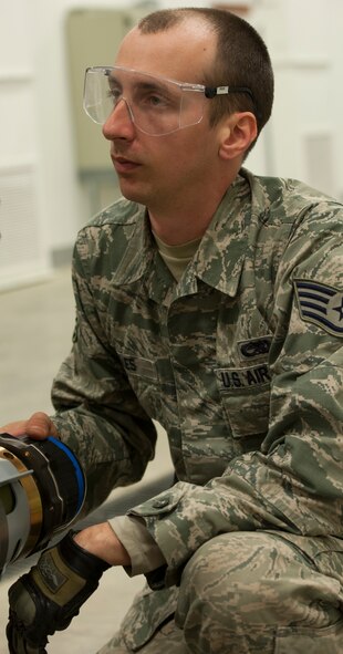 Staff Sgt. Brandon Jones, 5th Munitions Squadron , listens to instructions on how to install a component of a dummy bomb during a training session at Minot Air Force Base, N.D., May 7, 2014. Jones works with his team to ensure that Airmen understand the processes of putting munitions together and trains them to ensure that they are ready for exercises and real world events. (U.S. Air Force photo/Senior Airman Andrew Crawford)