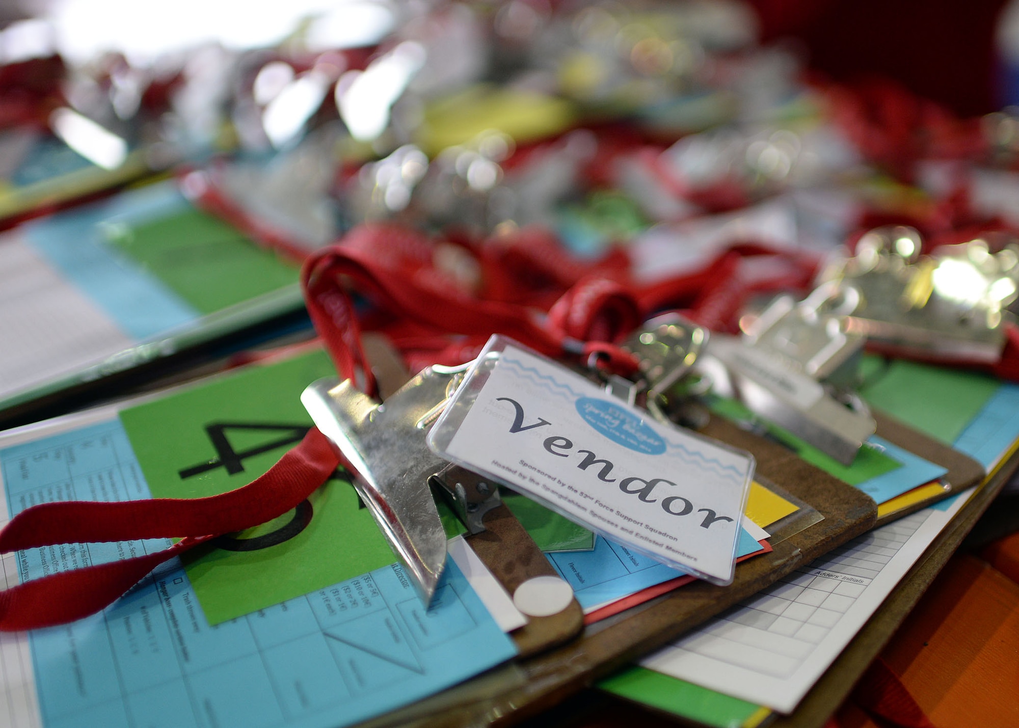 Clipboards rest on a table at the check-in station in Hangar 1 during the Spring Bazaar setup May 15, 2014, at Spangdahlem Air Base, Germany. Each vendor will receive their own unique documents to annotate their total sales cost. Last year, the Spangdahlem Spouses and Enlisted Members Club — the organization hosting the event — processed more than $380,000 worth of sales and gave more than $50,000 back to the Spangdahlem community. (U.S. Air Force photo by Staff Sgt. Daryl Knee/Released)