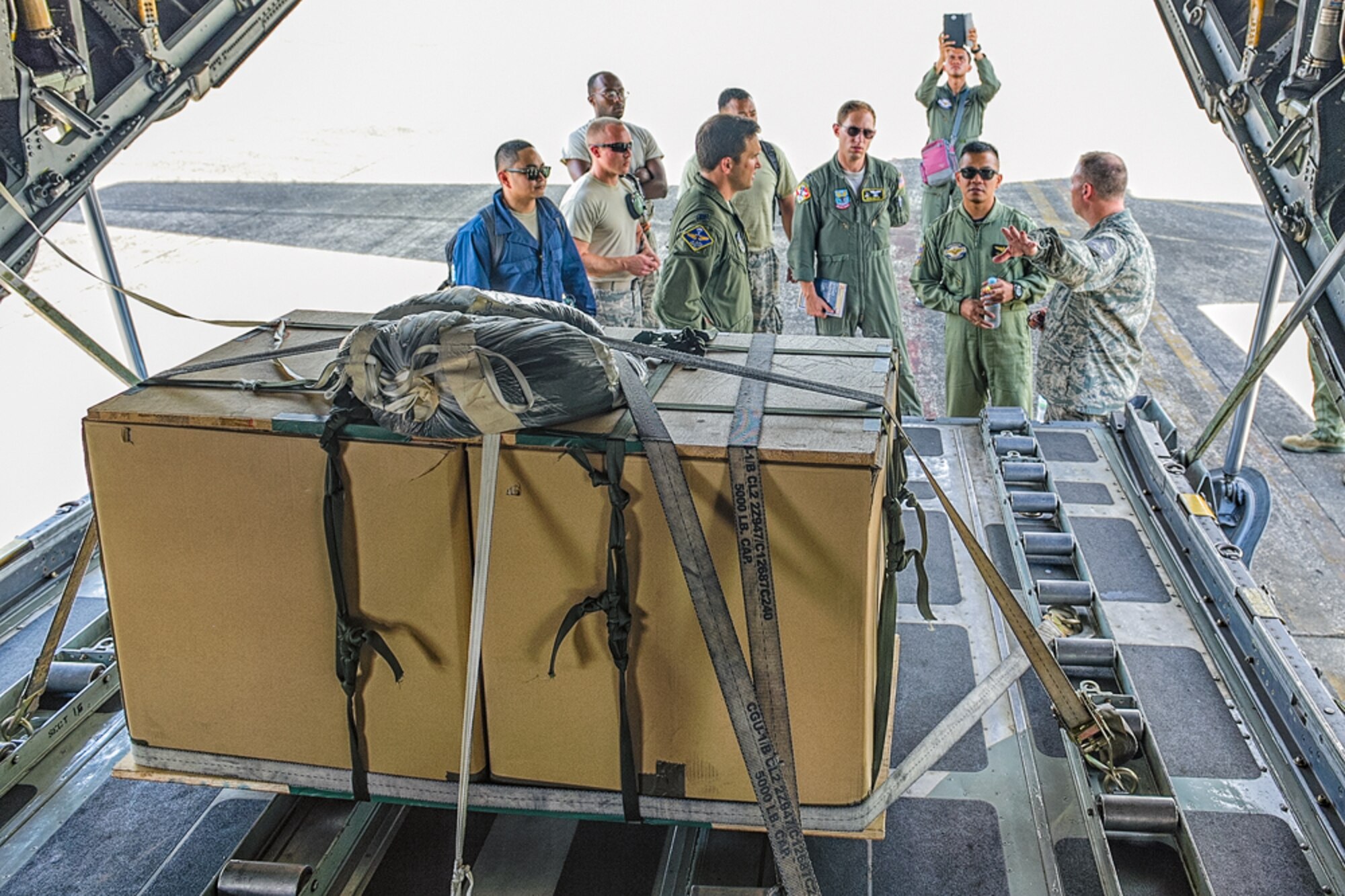 Members of the 374th Airlift Wing, Yokota Air Base, Japan, discuss a low-cost, low-altitude (LCLA) operations with Philippine Navy personnel during Exercise Balikatan near Basa, Republic of the Philippines May 14, 2014.  LCLA is a tactical airlift capability that accurately delivers humanitarian aid and supplies to remote regions with minimal rigging costs. (Courtesy photo by U.S. Air Force Maj. Teodoro Apalisok)