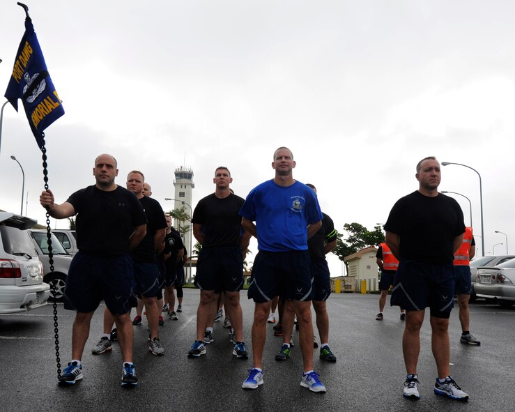 Members of the 733rd Air Mobility Squadron observe a moment of silence before a memorial run on Kadena Air Base, Japan, May 15, 2014, for 14 aerial transporters, also known as Port Dawgs, who have given their lives in the past year. The memorial run, which is scheduled to be held annually, was part of National Transportation Week. (U.S. Air Force photo by Senior Airman Marcus Morris)