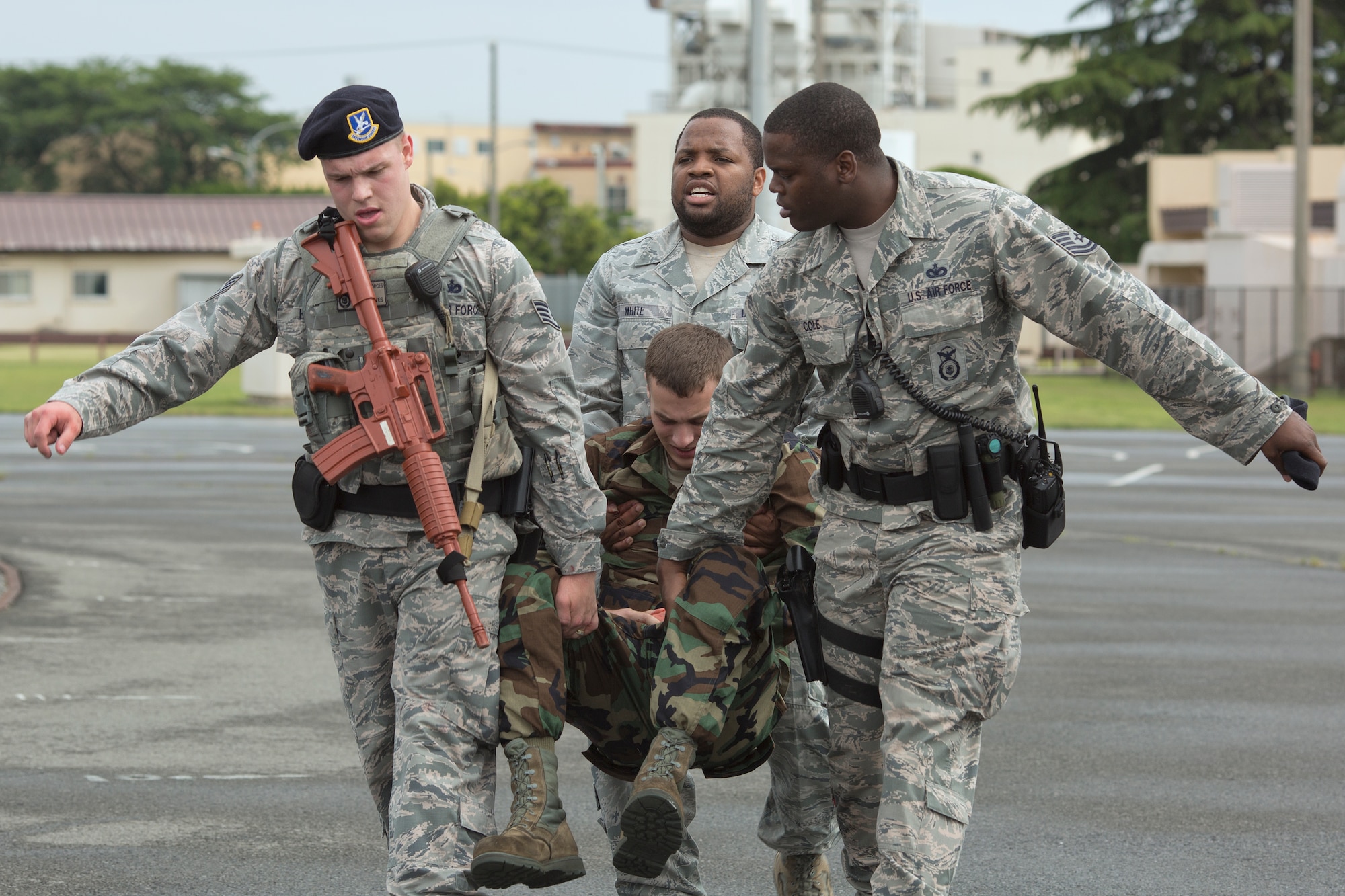 Airmen from the 374th Security Forces Squadron carry a simulated wounded victim during a simulated active shooter scenario at Yokota Air Base, Japan, May 15, 2014. The scenario, part of Yokota’s Samurai Readiness Inspection, tested emergency responders’ ability to respond to a shooter and base’s ability to handle the aftermath of a violent incident. (U.S. Air Force photo by Osakabe Yasuo/Released)