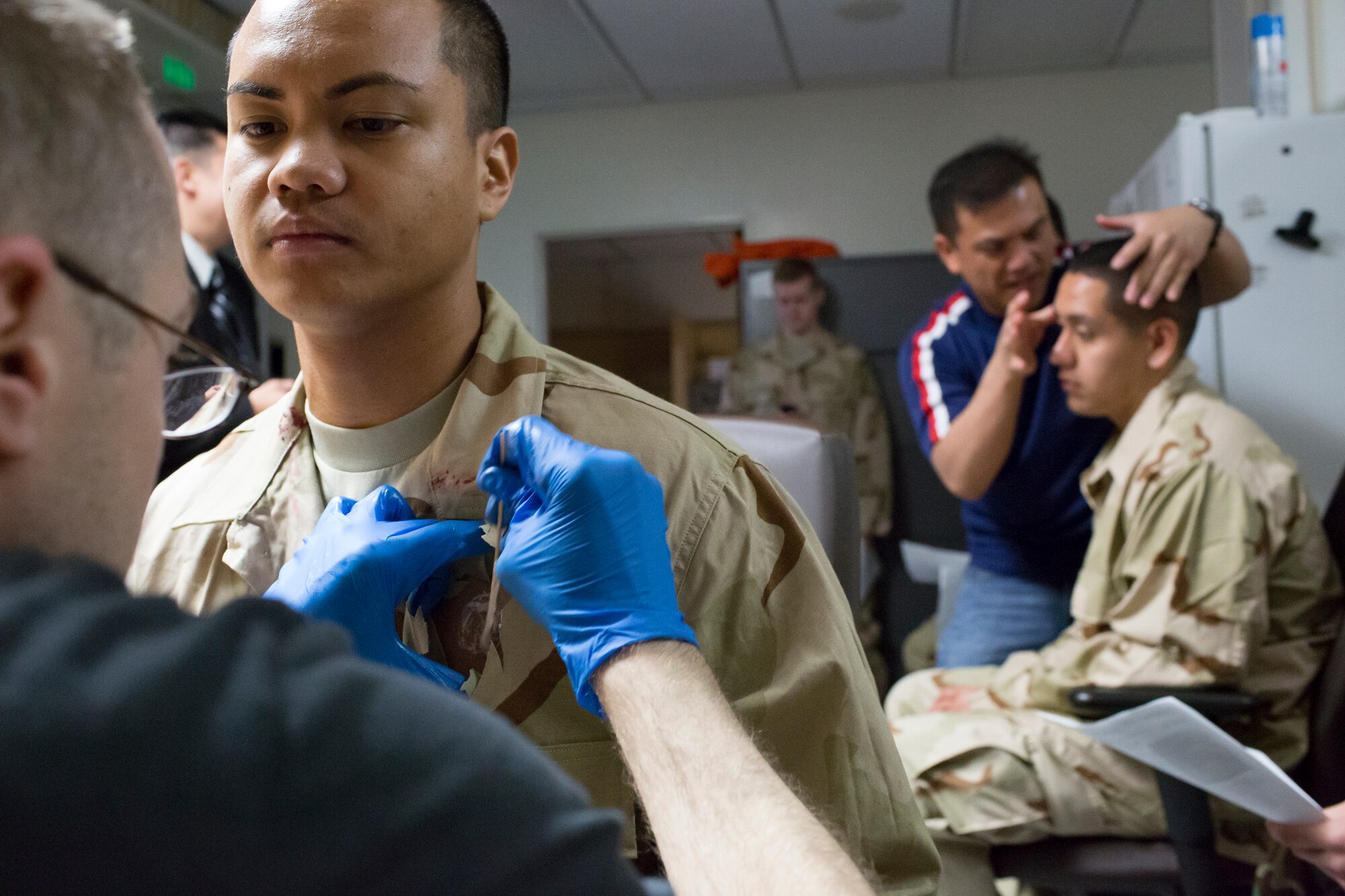 (Right to left) Staff Sgt. Brandon Joyce, 374th Surgical Operations Squadron, and Tech. Sgt. Christopher Bueno, 374th Medical Support Squadron, apply mock injuries to role players prior to a active shooter scenario during a Samurai Readiness Inspection at Yokota Air Base, Japan, May 15, 2014. The fake injuries create a sense of realism for first responders and enhance the effectiveness of the training conducted. (U.S. Air Force photo by Osakabe Yasuo/Released)