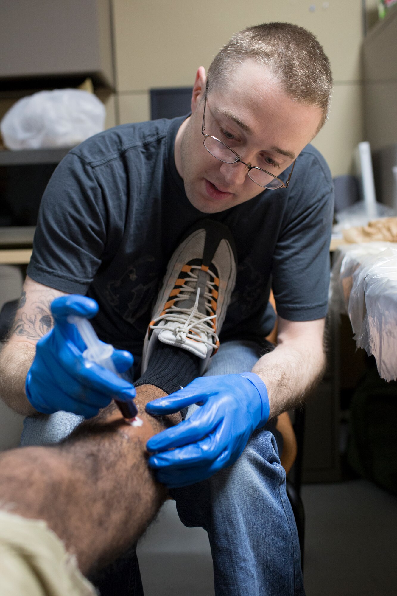 Staff Sgt. Brandon Joyce, 374th Surgical Operations Squadron, applies mock injuries prior to a active shooter scenario during a Samurai Readiness Inspection at Yokota Air Base, Japan, May 15, 2014. The scenario enabled base emergency response personnel to practice their skills in dealing with an active shooter scenario. (U.S. Air Force photo by Osakabe Yasuo/Released)