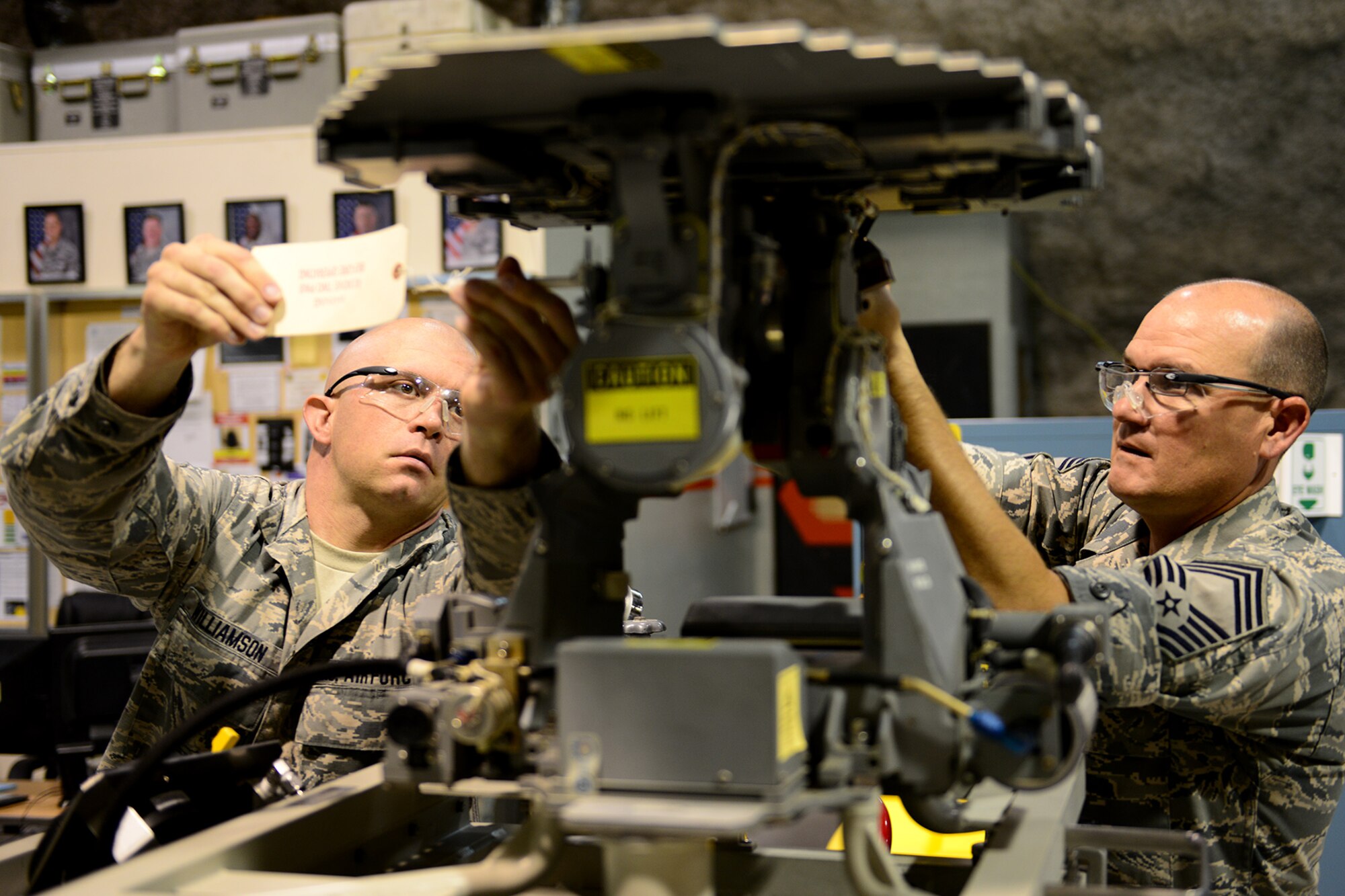U.S. Air Force Senior Airman Lance Williamson, 379th Expeditionary Maintenance Squadron avionics intermediate section team member, shows Chief Master Sgt. Paul Sharbutt, 379th Air Expeditionary Wing command chief, the operational check out of the F-16 radar antenna at Al Udeid Air Base, Qatar, May 13, 2014. The AIS operates under a centralized repair facility concept and is the only one in the area of responsibility. Williamson is deployed from Dannelly Field, Alabama and hails from Millbrook, Alabama. Sharbutt is from Picher, Oklahoma. (U.S. Air Force photo by Staff Sgt. Ciara Wymbs)