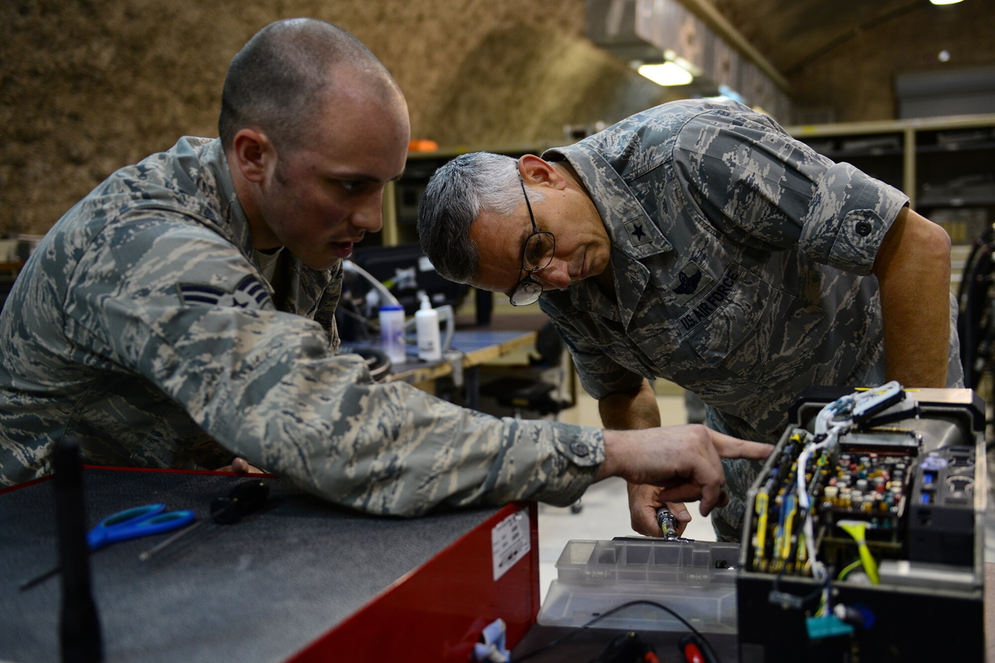 U.S. Air Force Senior Airman Jordan Thompson, 379th Expeditionary Maintenance Squadron avionics intermediate section team member, shows Brig. Gen. Roger H. Watkins, 379th Air Expeditionary Wing commander, how to properly install a cathode ray tube into an F-15E multipurpose display at Al Udeid Air Base, Qatar, May 13, 2014. The AIS which operates under a centralized repair facility concept is the only one in the entire area of responsibility. Thompson is deployed from Royal Air Force Lakenheath, United Kingdom and hails from Alexandria, Indiana. Watkins is from Fort Worth, Texas. (U.S. Air Force photo by Staff Sgt. Ciara Wymbs)