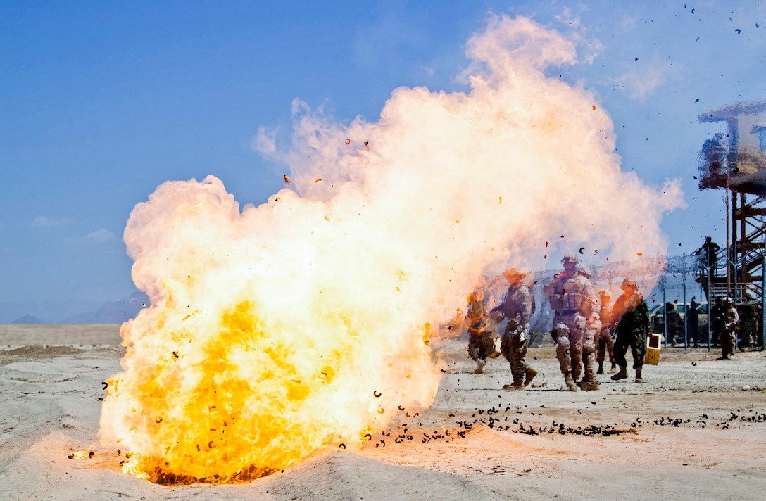 U.S. Defense Department contractors and linguists working with the Regional Corps Battle School watch as mortar increments burn near Camp Shorabak in Afghanistan's Helmand province, May 4, 2013. U.S. Marines provided sucurity while the school's instructors while instructors trained Afghan soldiers to improve proficiency with the 60mm mortar system.  
