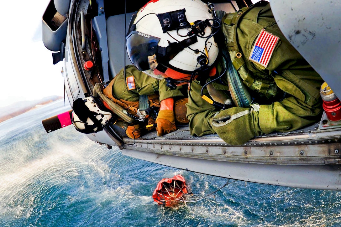 Navy Chief Petty Officer Jay Okonek, left, and 1st Class Petty Officer Jason Blase help guide pilots as they fill a 360-gallon Bambi bucket to help extinguish fires near Naval Base Ventura County's base housing at Point Mugu, Calif., May 3, 2013.  
