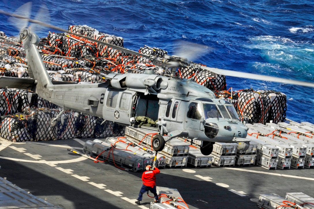 A U.S. sailor aboard the Military Sealift Command dry cargo and ammunition ship USNS Richard E. Byrd attaches cargo to an MH-60S Seahawk helicopter while conducting a replenishment with the aircraft carrier USS Nimitz underway in the Pacific Ocean, April 28, 2013. The Seahawk is assigned to Helicopter Sea Combat Squadron 6. 
