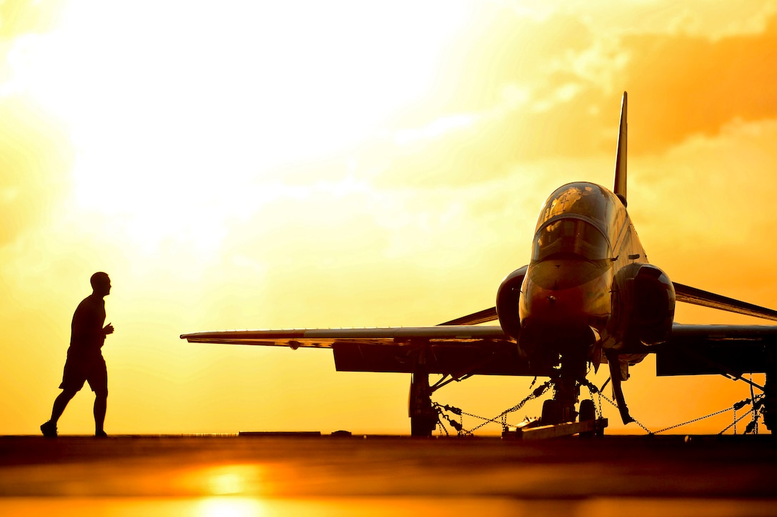 A U.S. sailor runs on the flight deck of the aircraft carrier USS George H.W. Bush during sunset in the Atlantic Ocean, April 26, 2013. The Bush is conducting training operations.  
