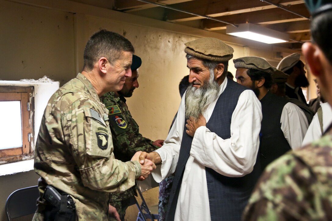 U.S. Army Col. J.P. McGee, left, speaks with Haji Mosolen, chief of the shura, during a meeting on Forward Operating Base Bostic in Kunar province, Afghanistan, April 20, 2013. McGee is commander of the 101st Airborne Division's 1st Brigade Combat Team.  
