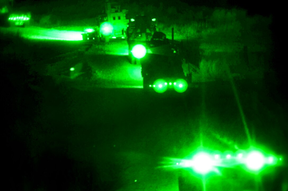 As seen through a night-vision device, U.S. Marines conduct a combat logistics patrol in Helmand province, Afghanistan, April 21, 2013. The Marines, assigned to Transportation Support Company, Combat Logistics Regiment 2, conducted the combat logistics patrol to resupply and support Regimental Combat Team 7.  
