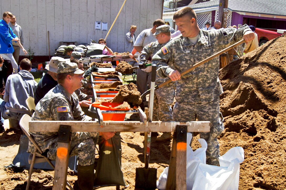 Soldiers fill sandbags during flood relief efforts in Clarksville, Mo., April 20, 2013. The soldiers are Missouri Army National Guardsmen assigned to the 2175th Military Police Company. Coast Guard, Army Corps of Engineers and National Guard units responded to major flooding along rivers in the Midwest.  
