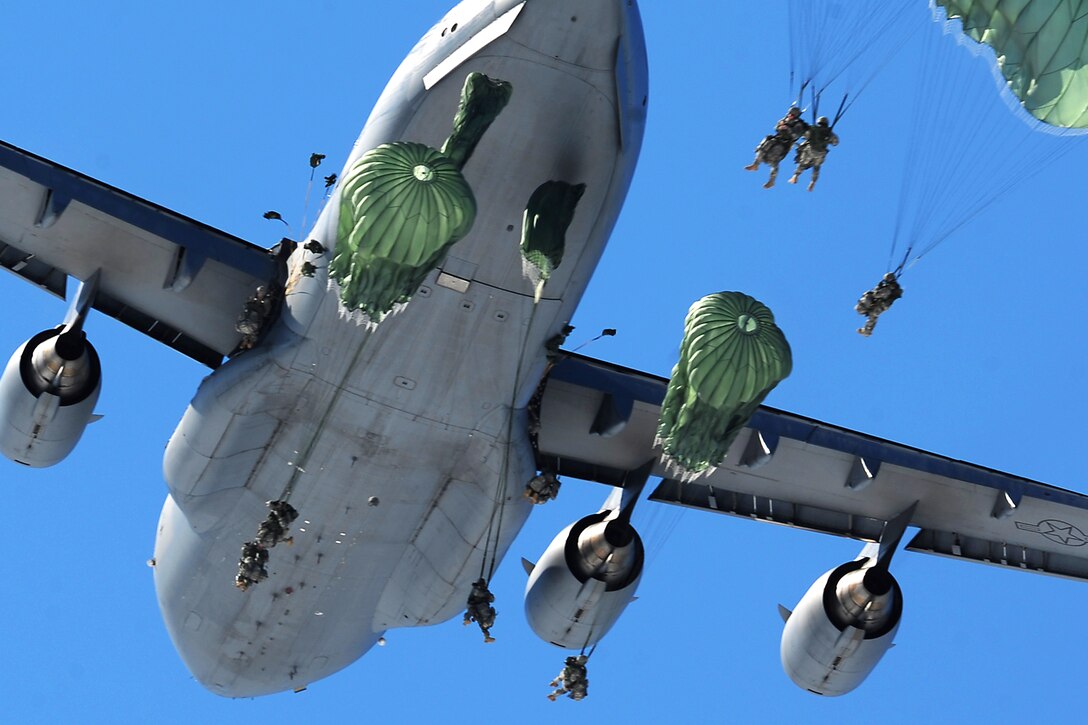 Paratroopers jump out of a C-17 aircraft while conducting airborne operations over Malamute Drop Zone on Joint Base Elmendorf-Richardson, Alaska, April 17, 2013.  
